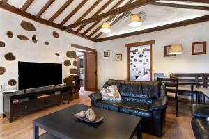 uma sala de estar com um sofá e uma televisão em Casa Abuelo Paco em Vega de San Mateo
