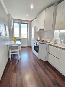 eine Küche mit weißen Schränken und Holzböden in der Unterkunft Micromegas apartments in Czernowitz