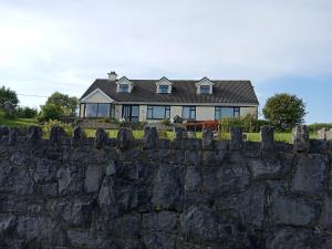 a house on top of a stone wall at Swan Studio Haven in Lisdoonvarna