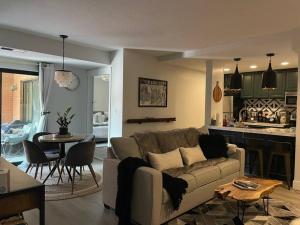 ein Wohnzimmer mit einem Sofa und einem Tisch sowie eine Küche in der Unterkunft 2 Bd/3 Ba, Luxury Ski-in Ski Out Condo - Sleeps 10 in Park City