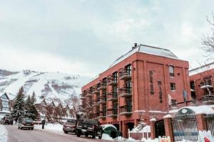ein großes rotes Backsteingebäude in einer verschneiten Straße in der Unterkunft 2 Bd/3 Ba, Luxury Ski-in Ski Out Condo - Sleeps 10 in Park City