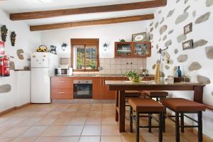 cocina con nevera, mesa y sillas en Casa Abuela Fela, en Vega de San Mateo