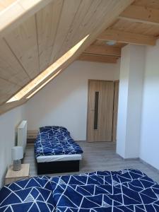 - une chambre avec un lit et un plafond en bois dans l'établissement Apartmány u Olšinské kapličky, à Horní Planá