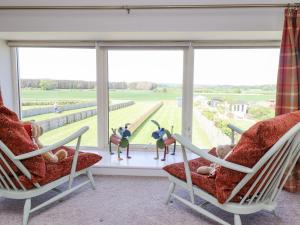 a living room with two chairs and a large window at The Mustard Pot in Acklington