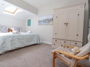 a bedroom with a bed and a chair and a cabinet at The Mustard Pot in Acklington