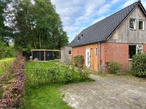 una casa con un jardín delante de ella en Vakantiehuisje drenthe gasselterveld, en Gasselte