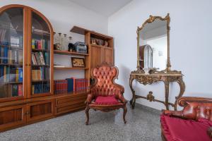 a living room with a chair and a mirror at Villa Emy in Messina
