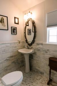 een badkamer met een wastafel, een toilet en een spiegel bij Stanley House Inn in Marietta