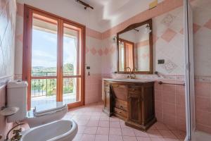 a bathroom with a sink and a toilet and a mirror at Villa Emy in Messina +21 photos