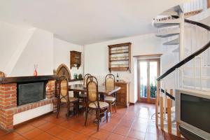 una sala da pranzo con tavolo, sedie e televisione di Stone house and dependance 7 pers a Moltrasio