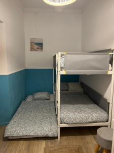 two bunk beds in a room with blue walls at Quinta da Layla in Olhão