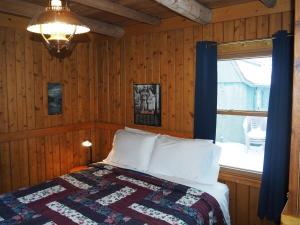 a bedroom with a bed with a quilt and a window at The Crystalaire Cabin - Charming And Relaxing! in Frankfort
