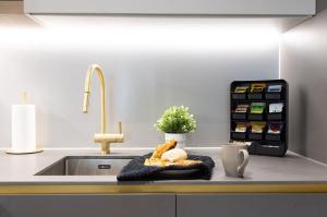 a kitchen sink with a plate of food on a counter at ShySuite 1BED in London +16 photos