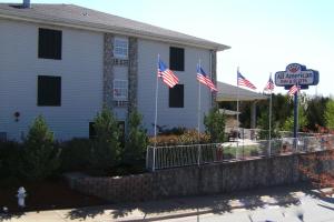 Ein Gebäude mit amerikanischen Flaggen davor in der Unterkunft All American Inn & Suites Branson in Branson