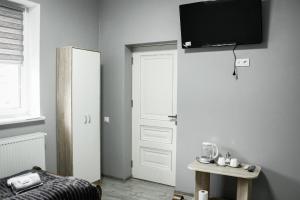 Pokój z drzwiami i telewizorem na ścianie w obiekcie Margo w Jaremczach