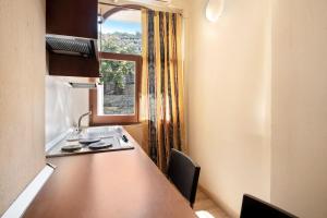 - une cuisine avec une table et une fenêtre dans une chambre dans l'établissement Appartamento Monolocale Moneglia 24, à Moneglia