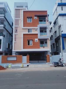 un edificio con un estacionamiento delante de él en Furnished 3 BHK in Prime Location Near Arilova - 3rd Floor en Visakhapatnam