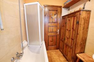 a bathroom with a shower and a wooden door at Dolce Casa vicino a Bormio in SantʼAntonio +17 photos