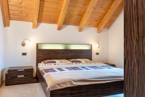 Schlafzimmer mit einem großen Bett mit einem Kopfteil aus Holz in der Unterkunft Appartment Bergweg in Lajen