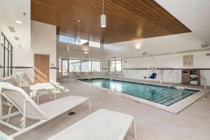 a large swimming pool with chairs and a table at Element Denver International Airport in Denver