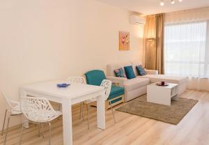 een woonkamer met een witte tafel en stoelen bij Coastal 1BD Flat with Pool & Parking in Varna