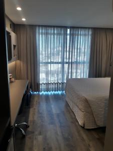 a bedroom with a bed and a large window at Hotel Le Canard Lages in Lages