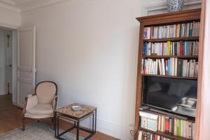 パリにあるNice apartment near the Pantheonのリビングルーム(テレビ、椅子、テーブル付)