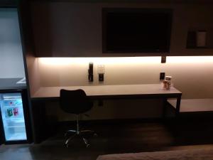 escritorio con silla y TV en la pared en Hotel Le Canard Lages, en Lages