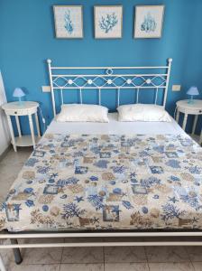 een bed in een kamer met een blauwe muur bij I SALICI in Capoliveri