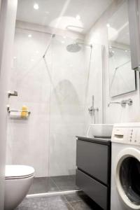 La salle de bains est pourvue d'une douche et d'un lave-linge. dans l'établissement Διαμέρισμα vasiliki στο κέντρο της Αθήνας, à Athènes