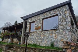 a stone building with a large window on it at Baba I Dede in Galičnik