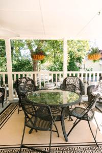 un patio con mesa de cristal y sillas en Stanley House Inn, en Marietta