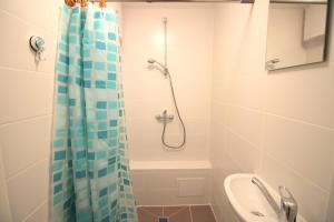 a bathroom with a shower with a blue shower curtain at Varpo st 10 Kaunas Students Home LT in Kaunas