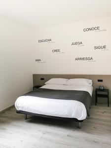 a bed in a room with a white wall at Apartamento rural en el Berguedà "Lluis & Antonia" A Ac in Sant Jordi de Cercs