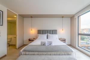 um quarto com uma cama grande e uma janela grande em Spectacular Loft In Luxury Building em Bogotá