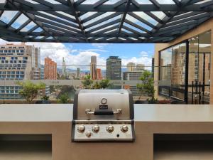 a grill on a counter with a view of a city at Spectacular Loft In Luxury Building in Bogotá