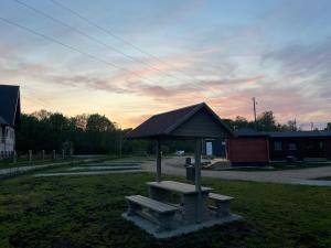 a picnic shelter with a bench in a park at WOMOCAMP Holzhütte 1 in Saulkrasti