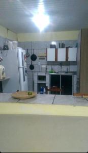 Il comprend une cuisine équipée d'un réfrigérateur et d'une table. dans l'établissement RECANTO DOS LIRAS, à Goiana