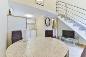 een woonkamer met een tafel en een trap bij Borik Apartment Pedic in Zadar