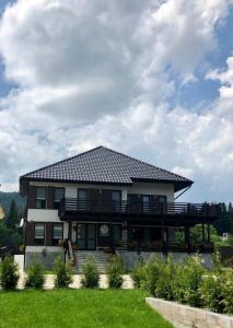 a large house with a deck on top of it at Pensiunea Edelweiss, Putna in Putna