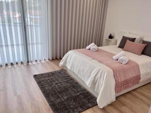 ein Schlafzimmer mit einem Bett mit zwei Handtüchern darauf in der Unterkunft Castelo View in Pombal