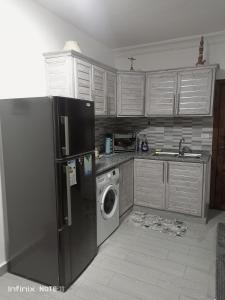 a kitchen with a refrigerator and a washing machine at Studio Apartment fully furnished super deloux 