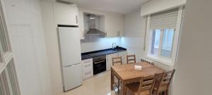 a white kitchen with a wooden table and a wooden tableablish at Palmeira in Ribeira