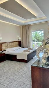a bedroom with a large bed and a large window at Hotel Sotiris Superior Apartments in Myrina