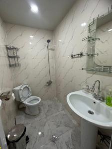 a white bathroom with a toilet and a sink at Ideal in Akhaltsikhe