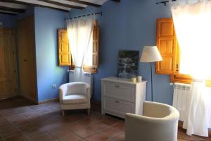 um quarto azul com uma cadeira e uma cómoda em EL MOLINO De Villel em Villel