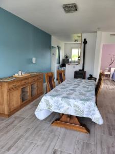 a dining room with a table and a kitchen at Gite Maison d'Allier in Le Veurdre