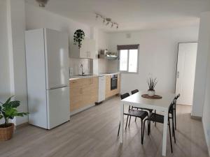 Il comprend une cuisine équipée d'une table et d'un réfrigérateur blanc. dans l'établissement Macarena´s Home *Sea view*-Saltillo Alto, à Torremolinos