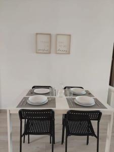 - une table blanche avec deux chaises et des assiettes dans l'établissement Macarena´s Home *Sea view*-Saltillo Alto, à Torremolinos