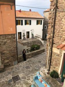 卡普拉亞的住宿－La Piazzetta，站在建筑物庭院中的女人